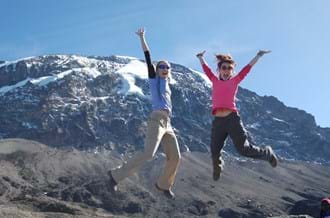 Two people jumping in the air at Kilimanjaro charity trek