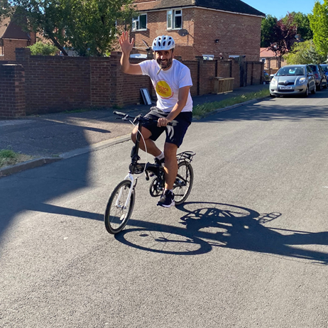 Place2Be supporter cycling and waving