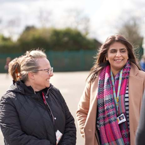 three school staff members chatting in playground