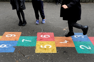 children playing hopscotch on school playground