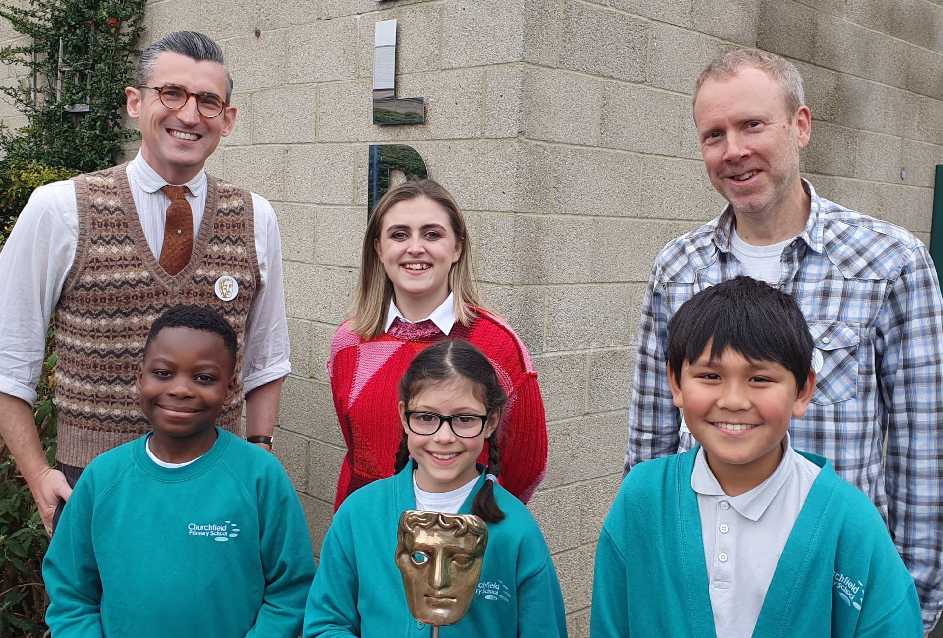 BAFTA Roadshow hosts Ben Shires (left) and Kia Pegg (centre), and guest speaker from Moonbug Entertainment Dan Balaam standing with Churchfield Primary School students.