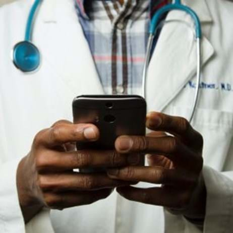 doctor in lab coat holding phone