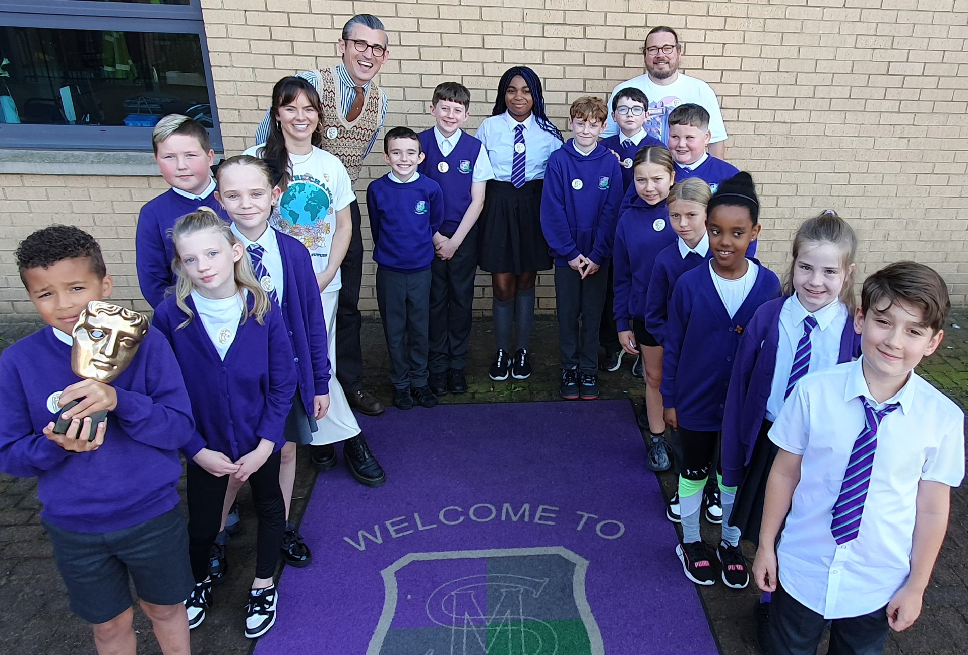 A group of students from St Monica's (Milton) Primary School standing with presenters Ben Shires, Robyn Richford (left) and Andrew Miller (Fuse Games).