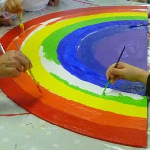 5 hands painting a rainbow