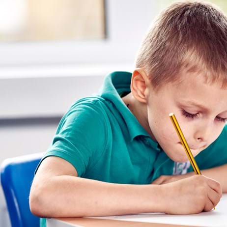 Boy drawing in classroom in school